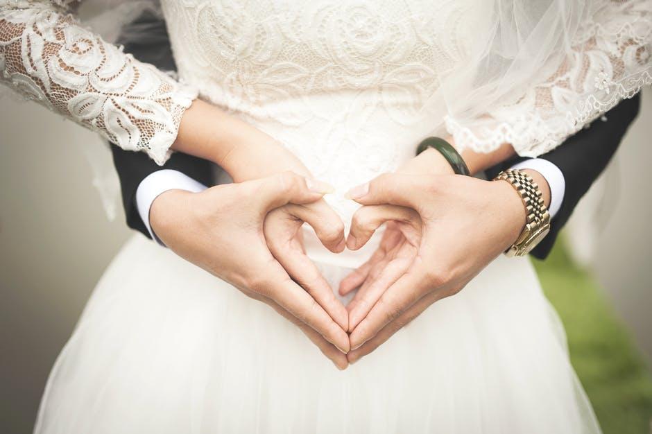 Midsection of Woman Making Heart Shape With Hands